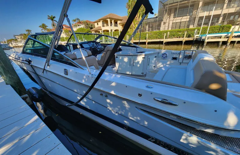 Slide: The Image of 2015 Four Winns Horizon H290 boat docked in a sunny marina setting. - 1