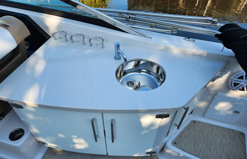 Slide: The Image of 2015 Four Winns Horizon H290 boat kitchenette with sink and storage cabinets. - 10