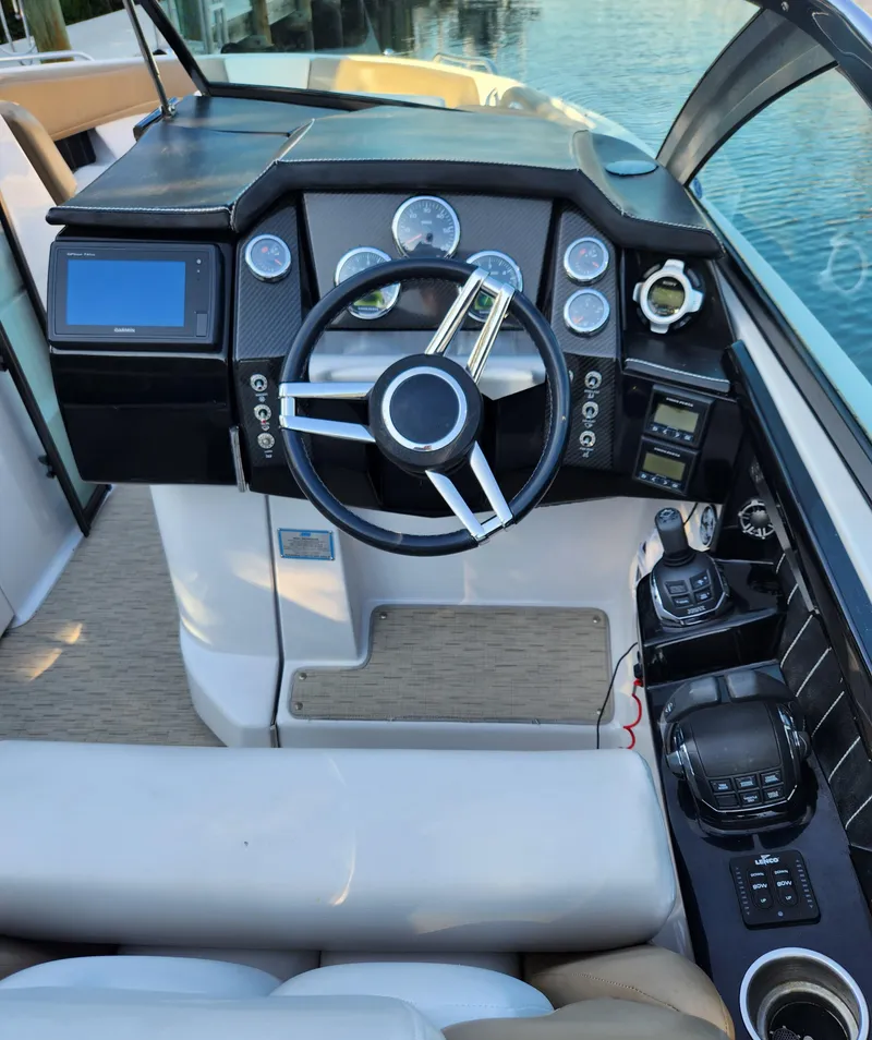 Slide: The Image of 2015 Four Winns Horizon H290 boat dashboard with steering wheel and control panel. - 13