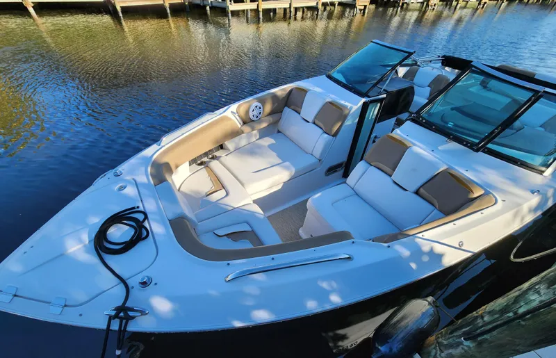 Slide: The Image of 2015 Four Winns Horizon H290 boat with spacious seating, docked on calm water. - 14