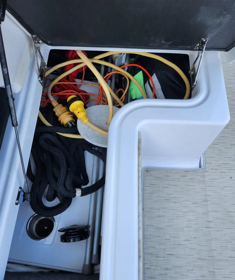 Slide: The Image of Storage compartment on a 2015 Four Winns Horizon H290 boat with cables and ropes. - 6