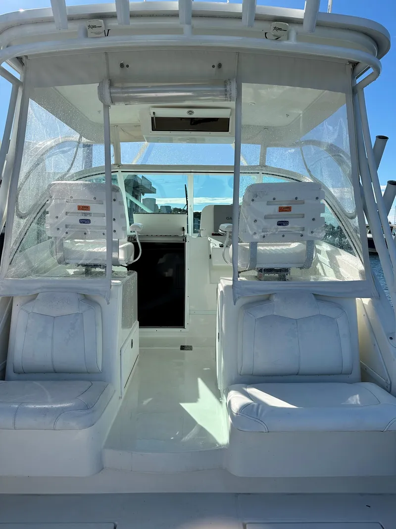 Slide: The Image of 2017 Albemarle 27 Express boat interior with white seating and helm station. - 13