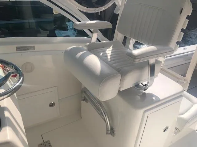 Slide: The Image of 2017 Albemarle 27 Express boat helm seat with white upholstery and armrests. - 15