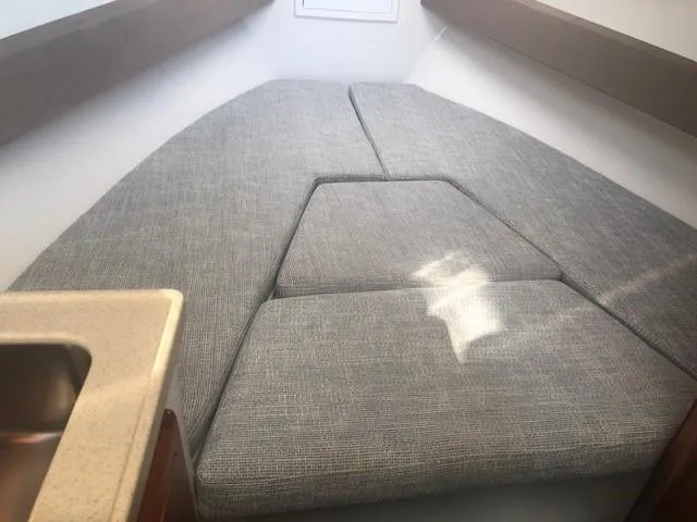 Slide: The Image of 2017 Albemarle 27 Express cabin interior with cushioned seating and compact sink. - 19