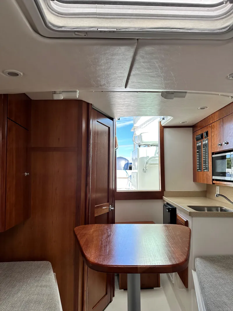 Slide: The Image of Interior of 2017 Albemarle 27 Express boat, featuring wood cabinetry and compact kitchen area. - 23