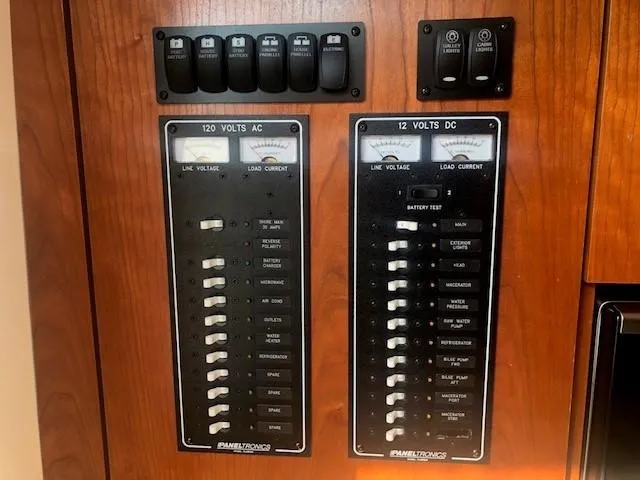 Slide: The Image of Electrical panel of a 2017 Albemarle 27 Express boat, featuring 120V AC and 12V DC switches. - 24