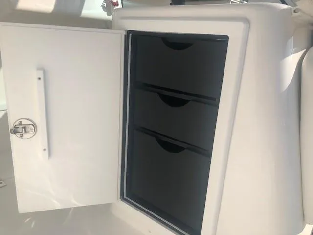 Slide: The Image of Albemarle 27 Express 2017 boat storage compartment with open door and drawers. - 31