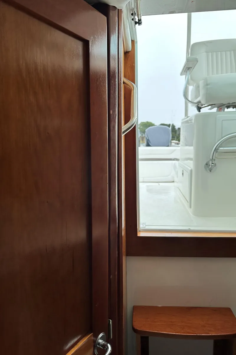 Slide: The Image of Interior view of 2017 Albemarle 27 Express boat, showing wooden door and window. - 32