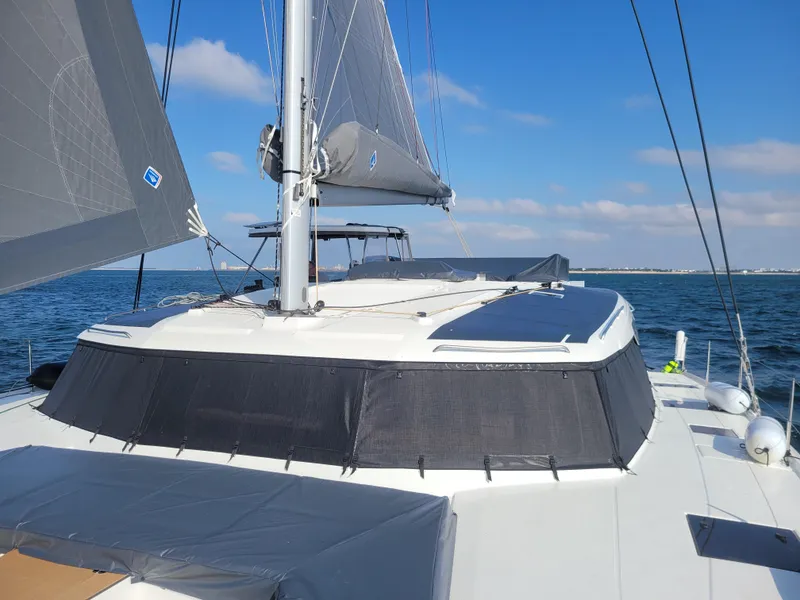 Slide: The Image of 2024 Fountaine Pajot Aura 51 sailing on open water under clear blue skies. - 8