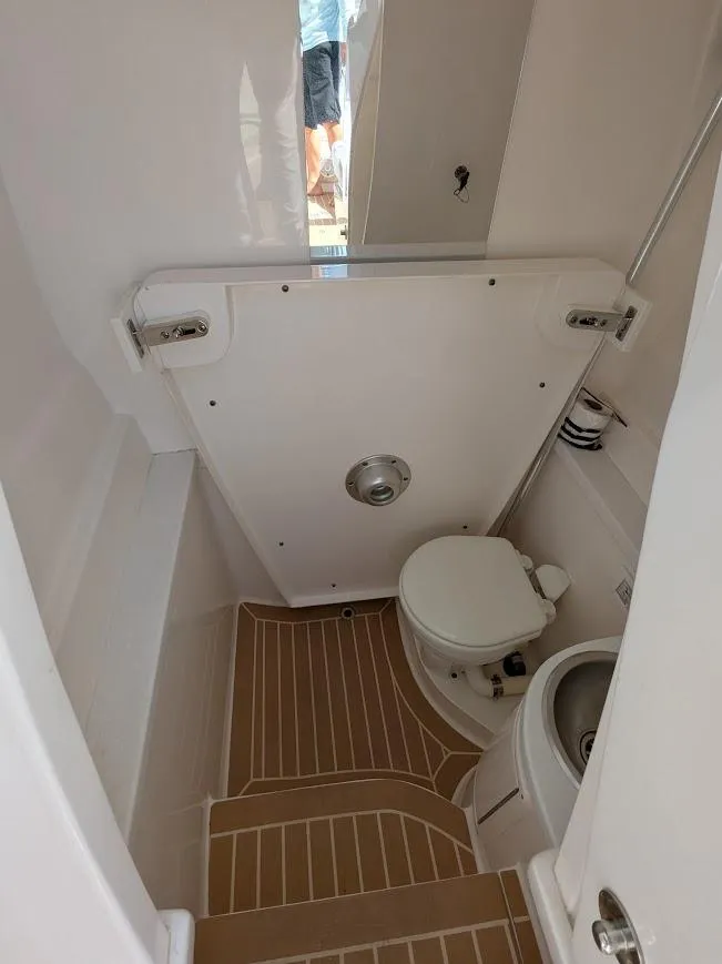 Slide: The Image of Interior of 2017 Intrepid 327 Center Console boat bathroom with toilet and sink. - 35