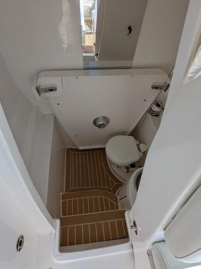 Slide: The Image of Intrepid 327 Center Console 2017 boat interior with compact marine toilet. - 37