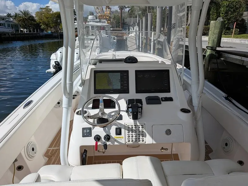 Slide: The Image of Intrepid 327 Center Console 2019, upgraded motors, helm view, docked, sunny day. - 49