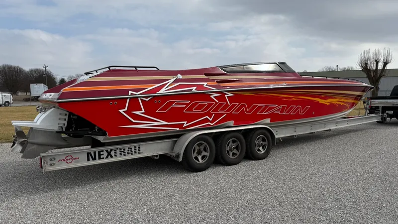 Slide: The Image of 2007 Fountain 42 Lightning speedboat on trailer, vibrant red design, parked outdoors. - 4