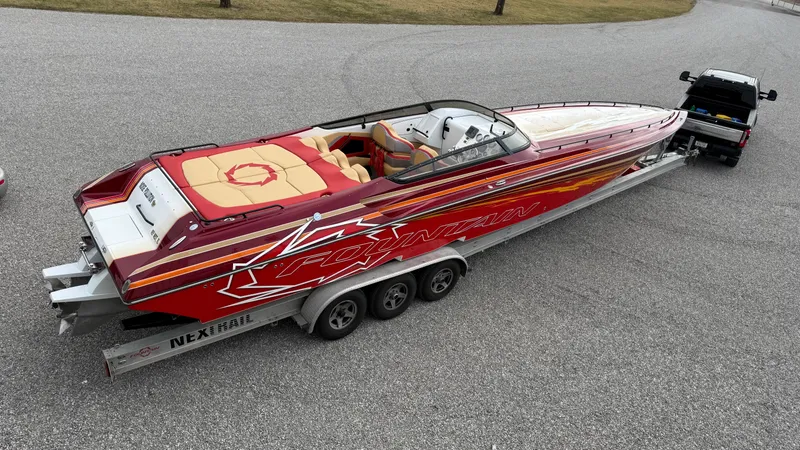 Slide: The Image of 2007 Fountain 42 Lightning speedboat on trailer, vibrant red design, parked on gravel. - 8
