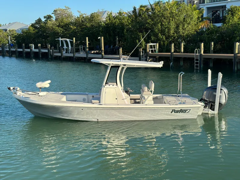 The Image of 2021 Parker 2600 SH boat on calm water near a dock, surrounded by greenery. - 0