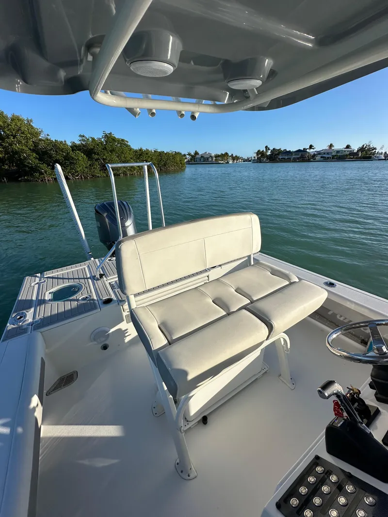 Slide: The Image of 2021 Parker 2600 SH boat with cushioned seating, steering console, and scenic water view. - 22