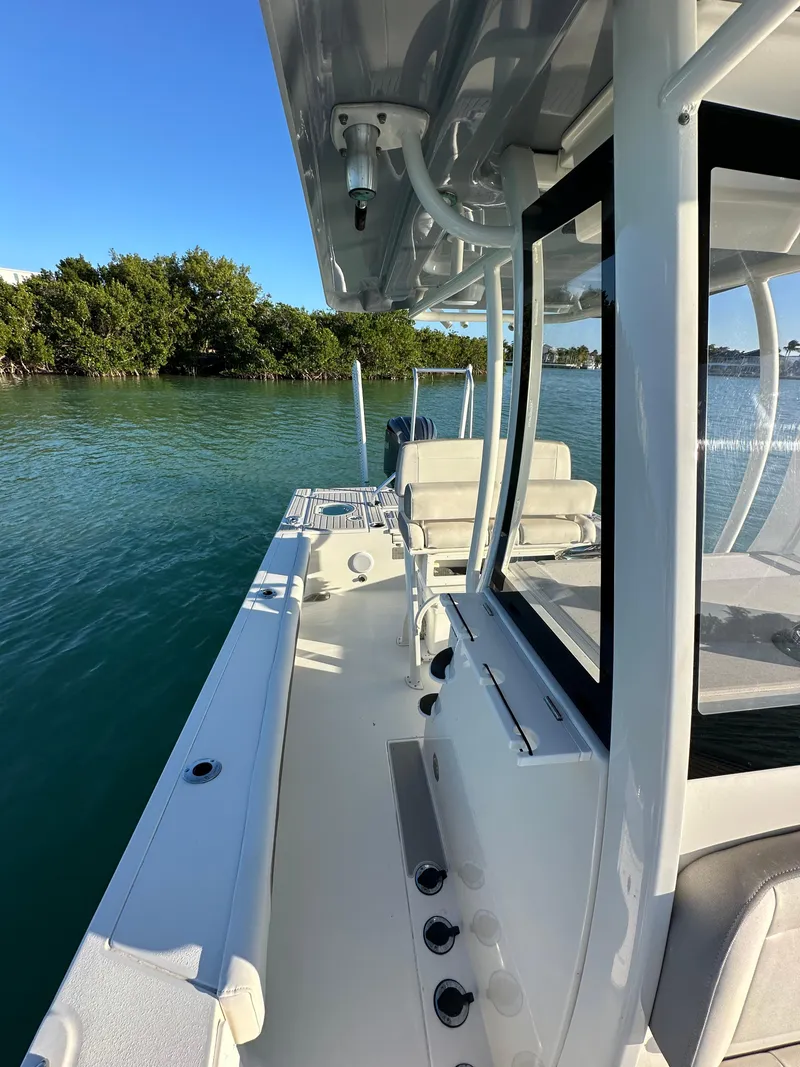 Slide: The Image of 2021 Parker 2600 SH boat on calm water, featuring sleek design and spacious deck. - 25