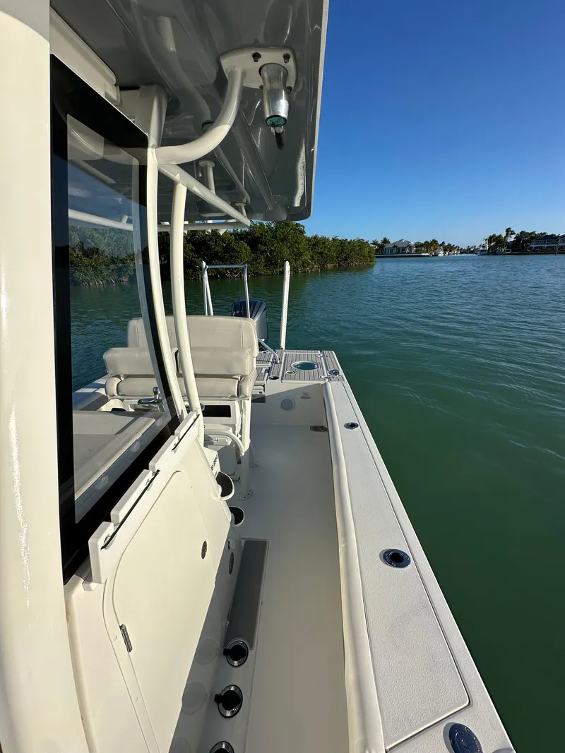 Slide: The Image of 2021 Parker 2600 SH boat on calm water, side view with clear sky. - 26