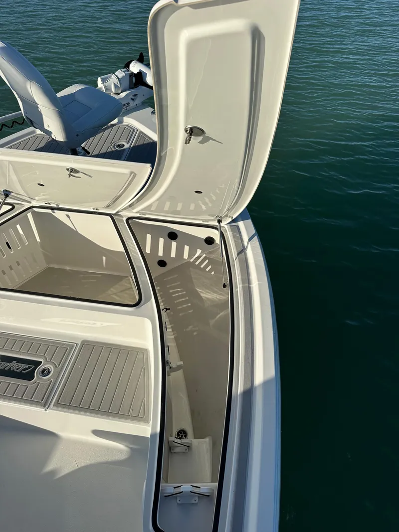 Slide: The Image of 2021 Parker 2600 SH boat with open storage compartment on calm water. - 33