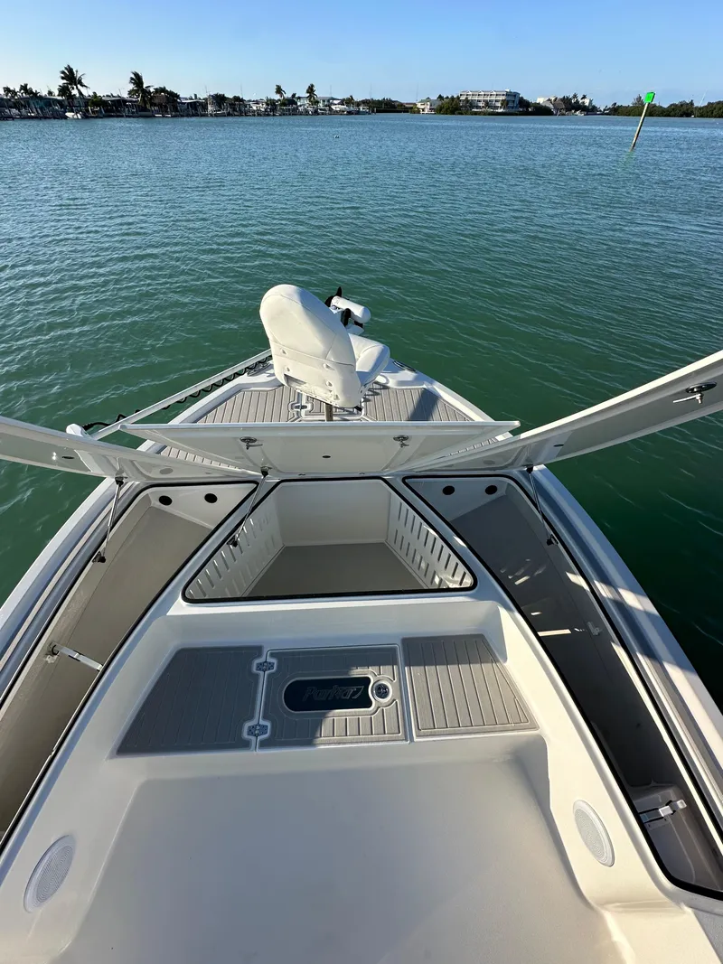 Slide: The Image of 2021 Parker 2600 SH boat on calm water, clear sky, and distant shoreline. - 35