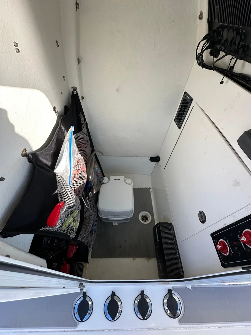 Slide: The Image of Interior of a 2021 Parker 2600 SH boat with storage and portable toilet. - 43