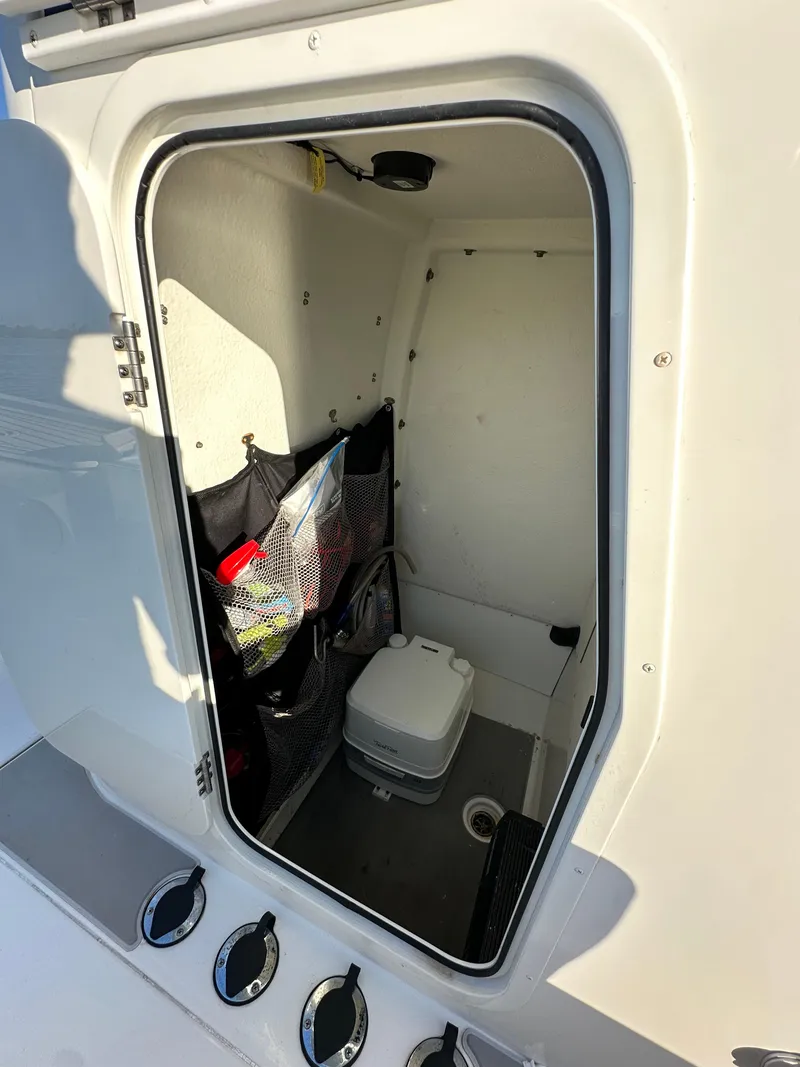 Slide: The Image of 2021 Parker 2600 SH boat storage compartment with portable toilet and storage nets. - 44