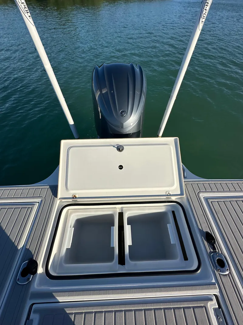 Slide: The Image of 2021 Parker 2600 SH boat with open storage compartments on deck, near water. - 8