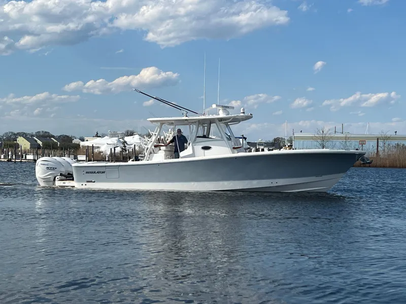Slide: The Image of 2024 Regulator 37 boat cruising on calm water under a partly cloudy sky. - 1