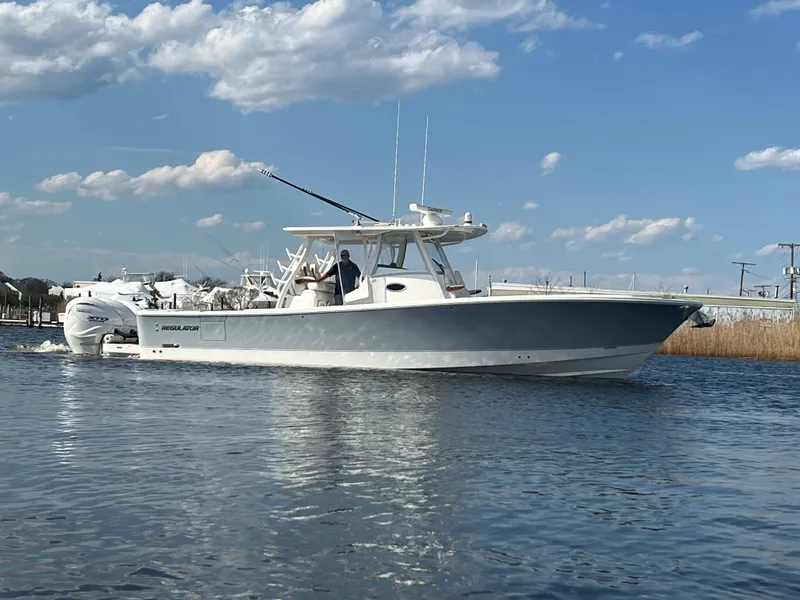 Slide: The Image of 2024 Regulator 37 boat on calm water under a partly cloudy sky. - 2