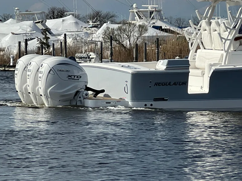 Slide: The Image of 2024 Regulator 37 boat with triple Yamaha XTO engines on calm water. - 21