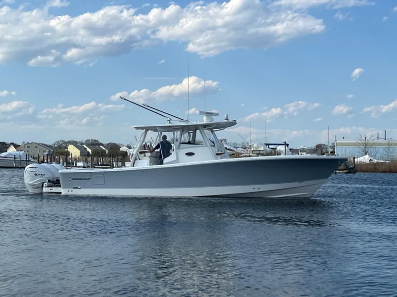 Slide: The Image of 2024 Regulator 37 boat cruising on calm water under a partly cloudy sky. - 22