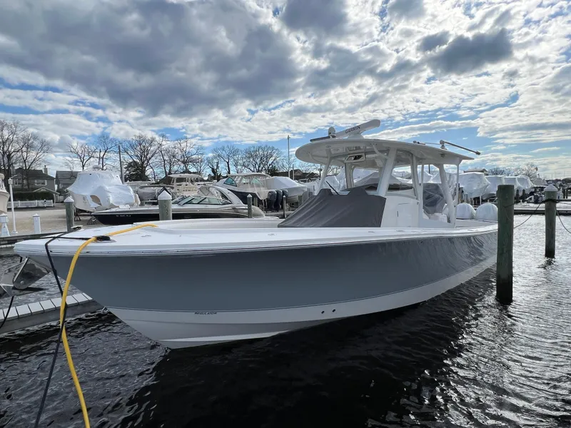 Slide: The Image of 2024 Regulator 37 boat docked under cloudy sky at marina. - 27