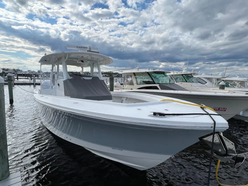 Slide: The Image of 2024 Regulator 37 boat docked under cloudy sky. - 28