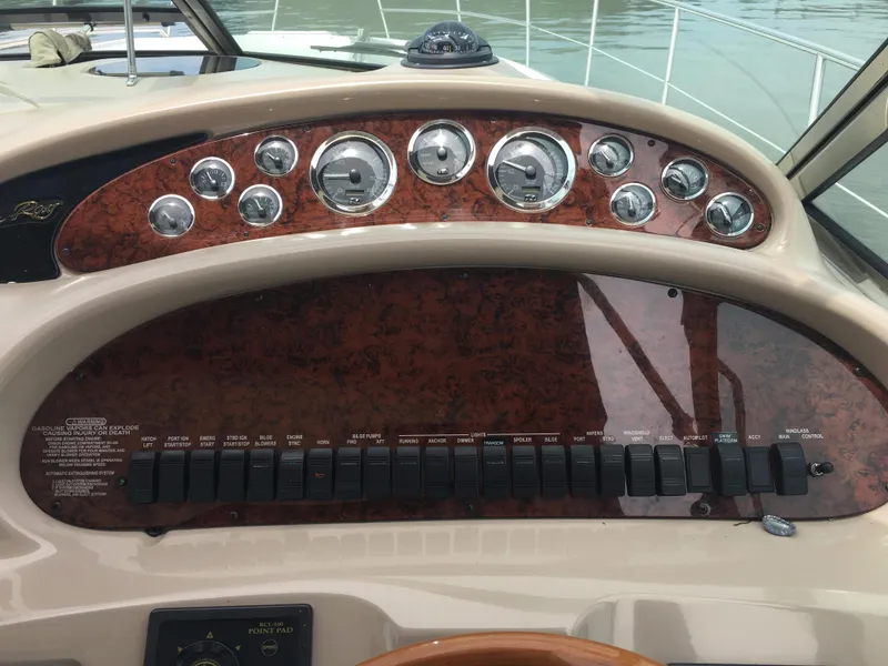 Slide: The Image of Dashboard of a 2000 Sea Ray 410 Sundancer boat with gauges and switches. - 17