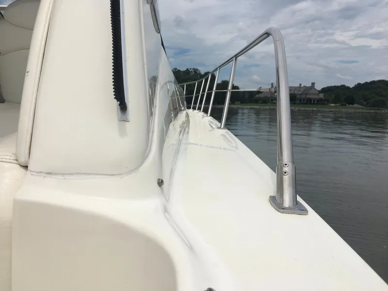 Slide: The Image of 2000 Sea Ray 410 Sundancer yacht deck with railing, calm water, and distant shoreline. - 22