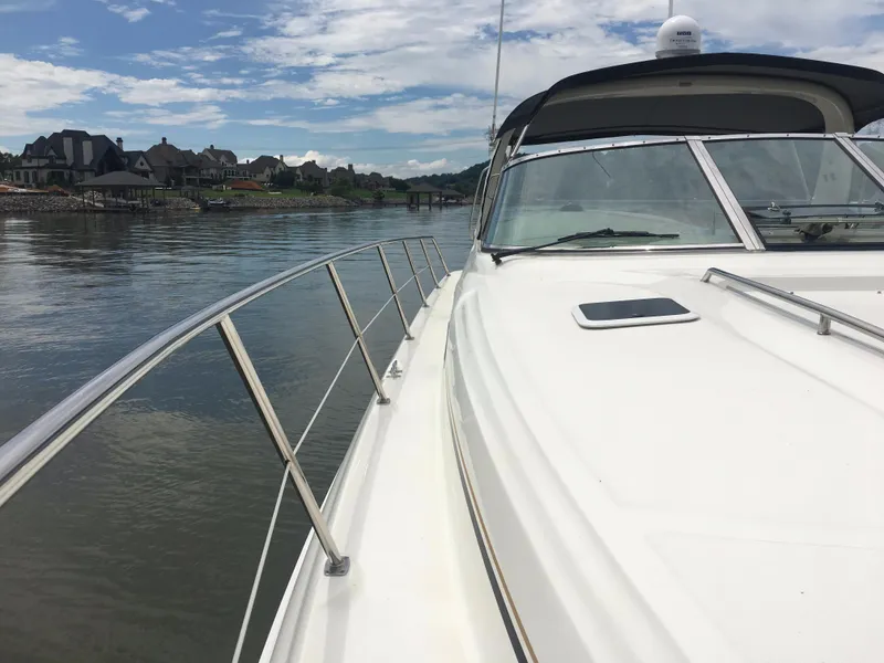 Slide: The Image of 2000 Sea Ray 410 Sundancer yacht cruising on a calm river under a partly cloudy sky. - 25