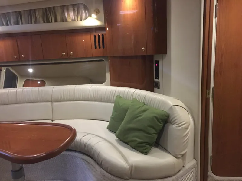 Slide: The Image of Interior of 2000 Sea Ray 410 Sundancer with white leather seating and wooden cabinetry. - 32
