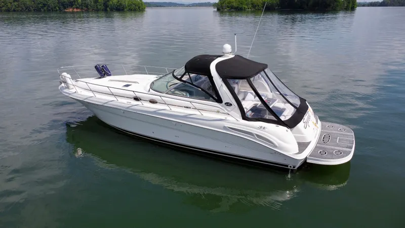 Slide: The Image of 2000 Sea Ray 410 Sundancer yacht on calm water, featuring sleek design and black canopy. - 4