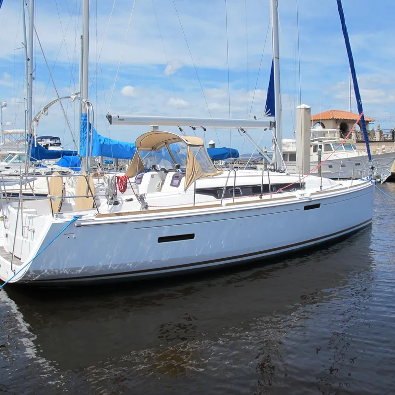 The Image of 2013 Jeanneau Sun Odyssey 379 sailboat docked in a marina under a clear sky. - 0