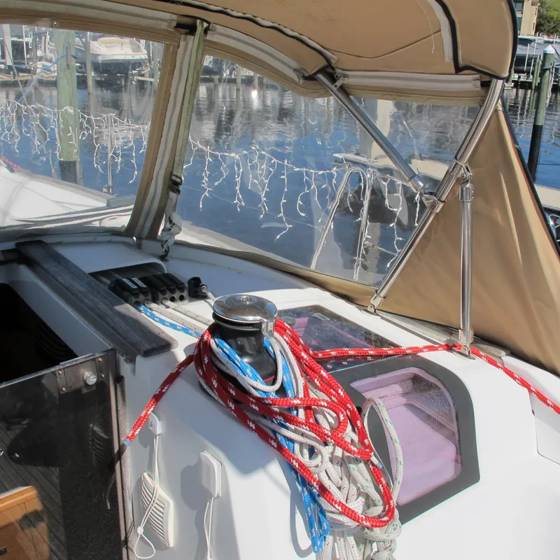 Slide: The Image of 2013 Jeanneau Sun Odyssey 379 sailboat cockpit with ropes and canopy in marina. - 14