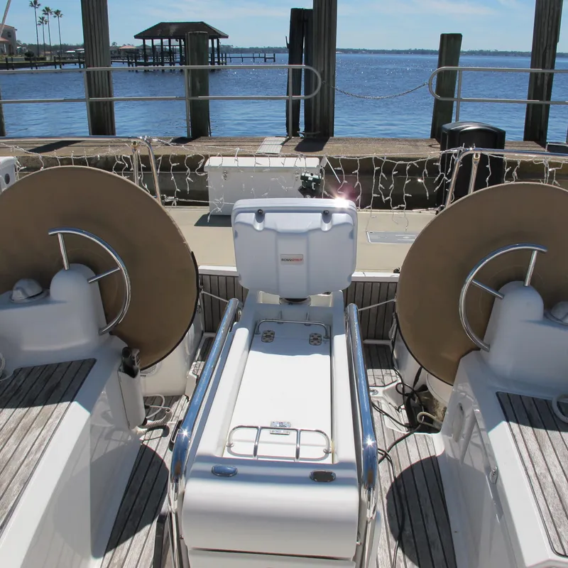 Slide: The Image of 2013 Jeanneau Sun Odyssey 379 yacht cockpit with dual steering wheels, docked by the water. - 15
