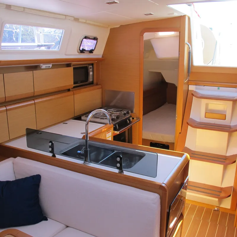 Slide: The Image of Interior of 2013 Jeanneau Sun Odyssey 379 yacht, featuring kitchen and seating area. - 26