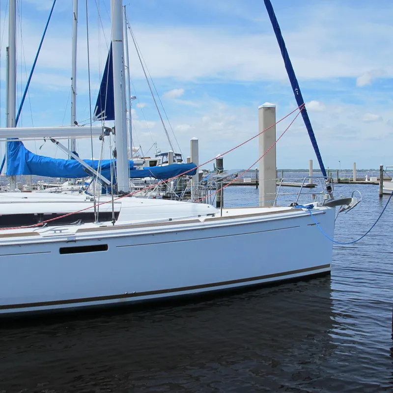 Slide: The Image of 2013 Jeanneau Sun Odyssey 379 sailboat docked in a marina under a clear sky. - 3