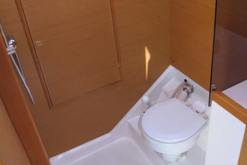 Slide: The Image of 2013 Jeanneau Sun Odyssey 379 yacht bathroom with compact toilet and wooden paneling. - 40