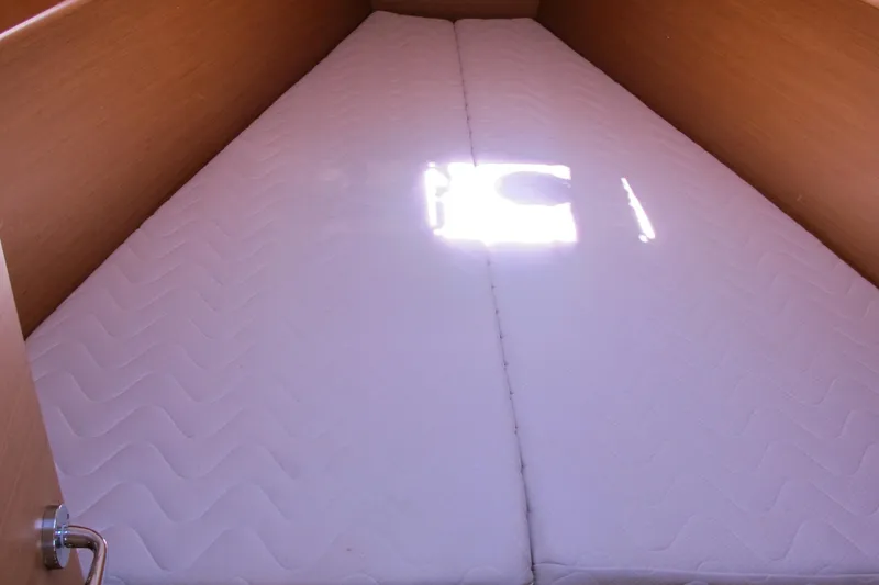 Slide: The Image of Cabin bed in 2013 Jeanneau Sun Odyssey 379 sailboat, featuring white mattress and wooden walls. - 44