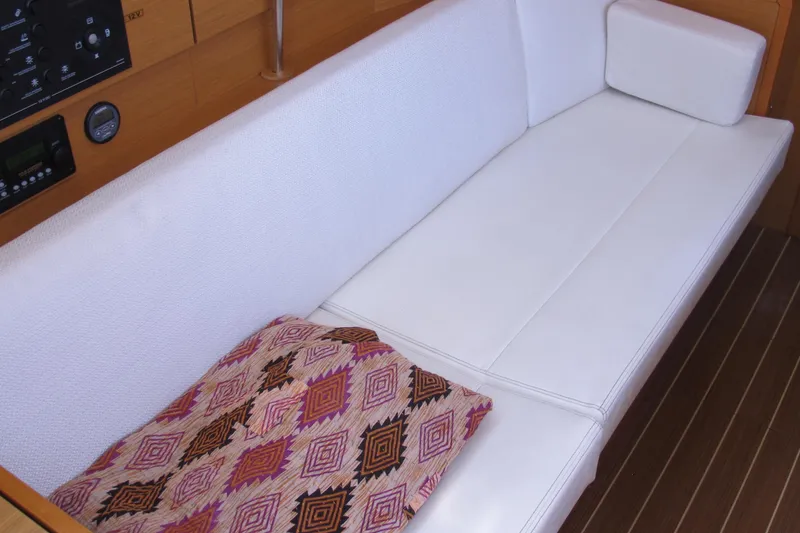 Slide: The Image of Interior of 2013 Jeanneau Sun Odyssey 379 with white seating and patterned cushion. - 80
