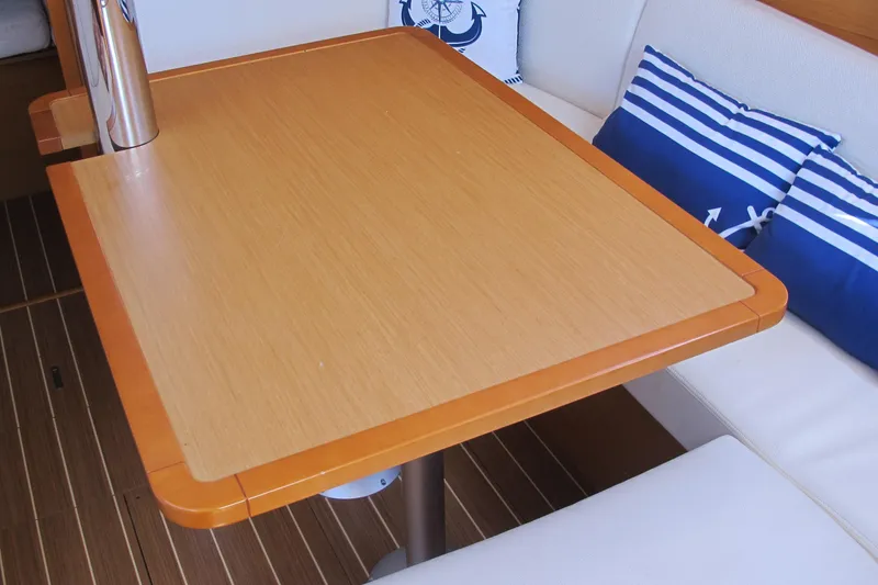 Slide: The Image of Interior of 2013 Jeanneau Sun Odyssey 379 with wooden table and nautical-themed cushions. - 81
