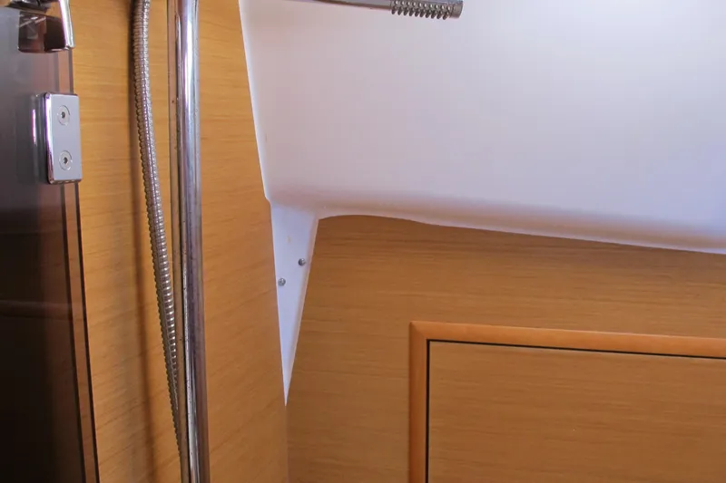 Slide: The Image of Interior view of 2013 Jeanneau Sun Odyssey 379 yacht, featuring wood paneling and metal fixtures. - 86