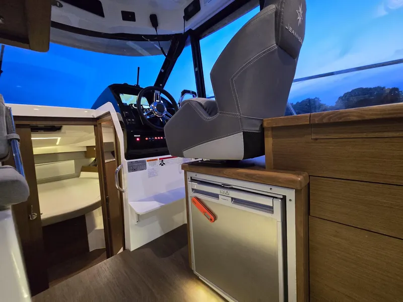Slide: The Image of Interior of 2021 Jeanneau NC895 boat with helm, seating, and cabin view. - 11