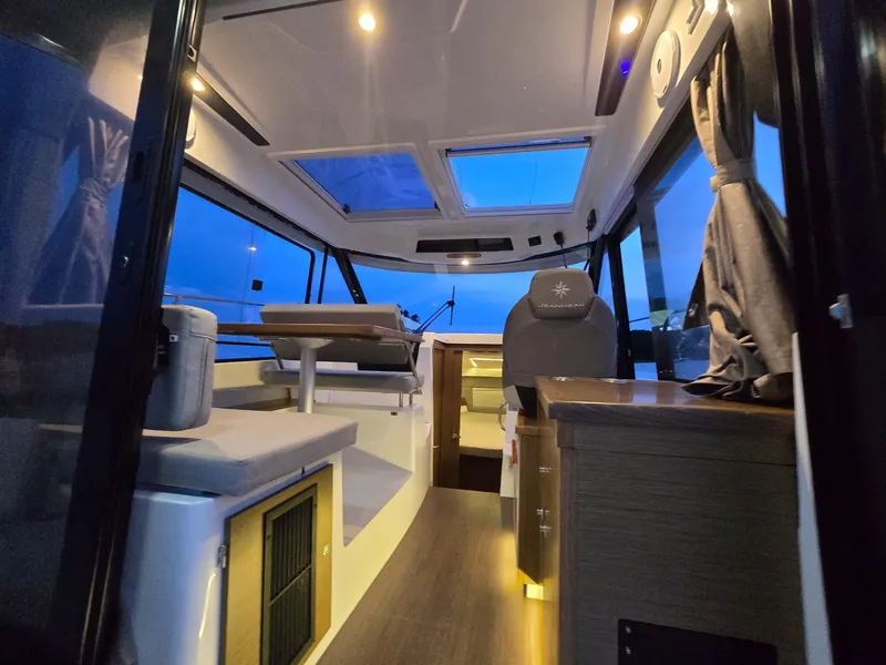 Slide: The Image of Interior of 2021 Jeanneau NC895 boat, featuring modern seating and ambient lighting. - 12